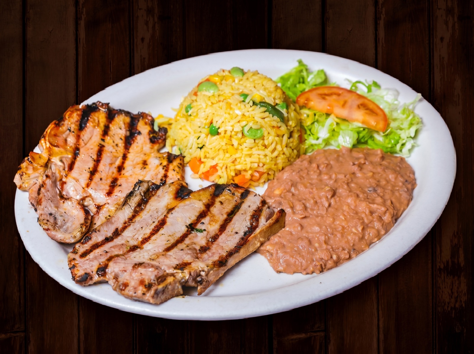 Carne asada plate with grilled steak, rice, beans and guacamole