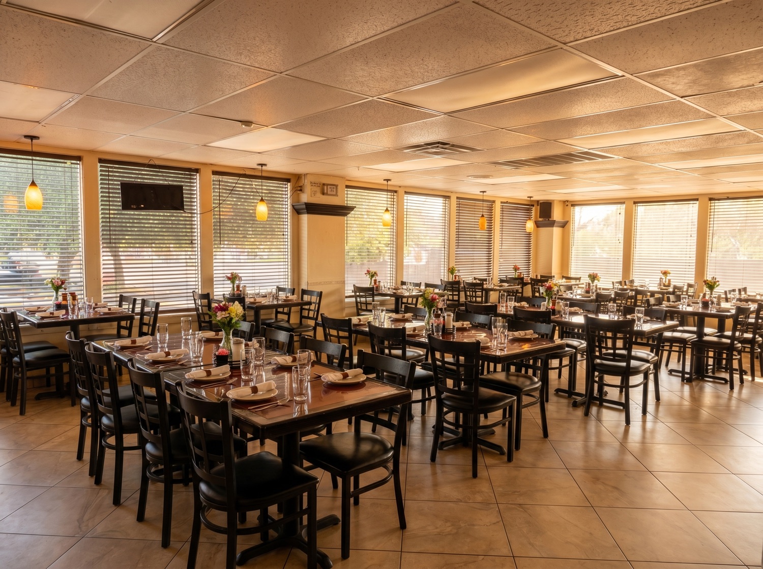 Warm dining room with set tables and fresh flowers