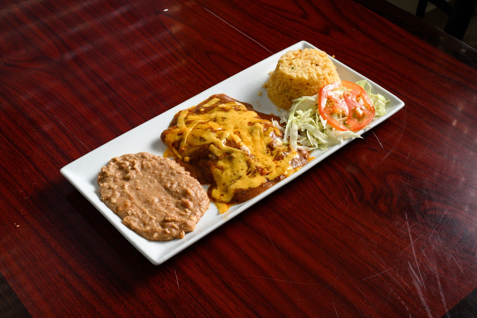 A plate with rice and beans on the house’s mahogany tables
