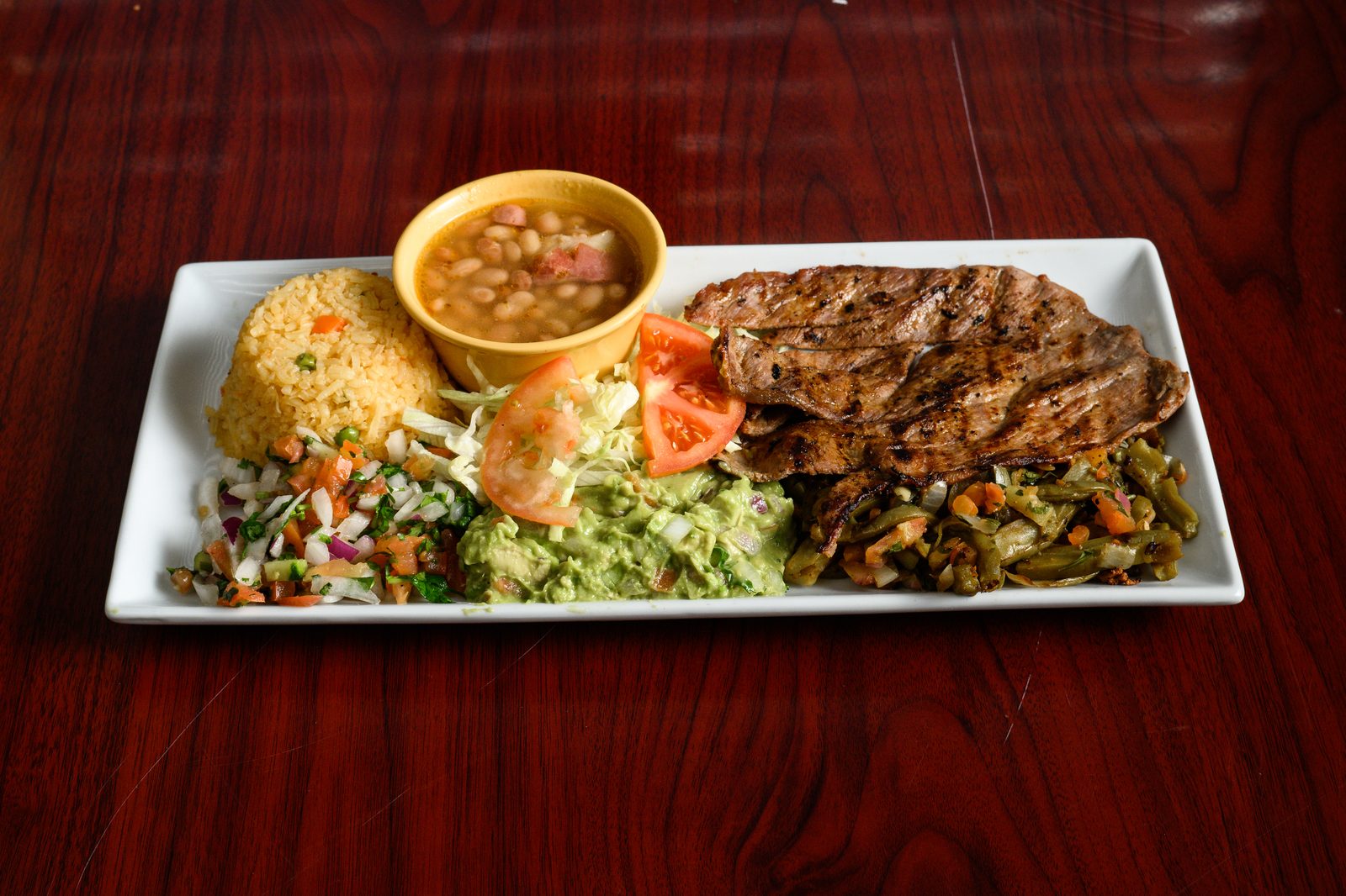 Carne asada plate with rice, beans and guacamole