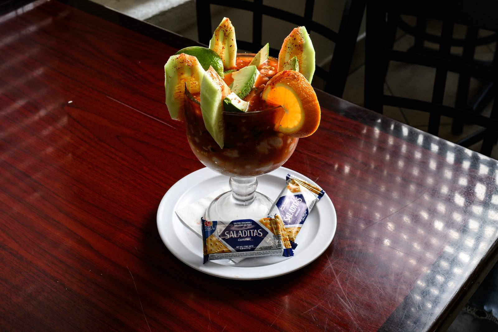 Seafood cocktail in a tall glass with crackers
