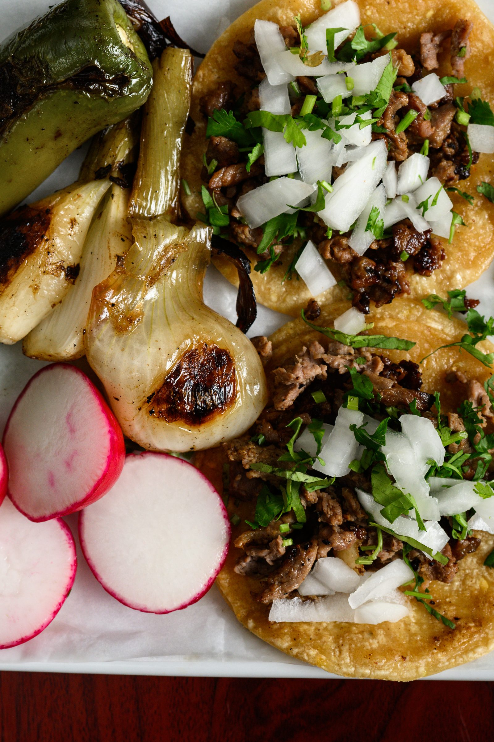 Tacos with grilled onion, radish and lime